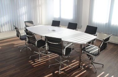 Modern office meeting room with designer chairs, table, and large windows.